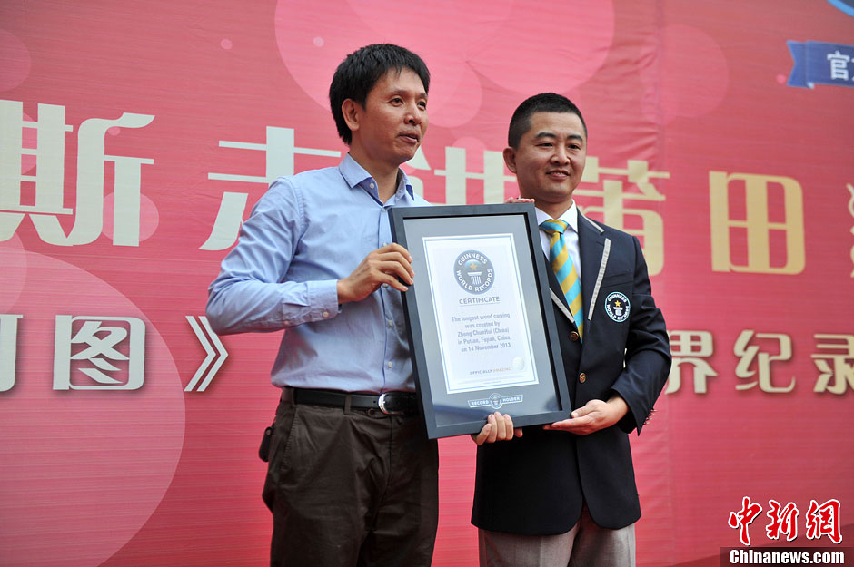 圖為世界吉尼斯認證官為鄭春輝（左）頒發證書。呂明 攝